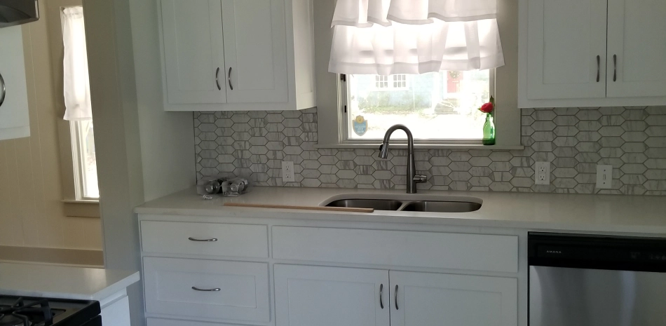 beige kitchen with white cabinets and a white kitchen sink